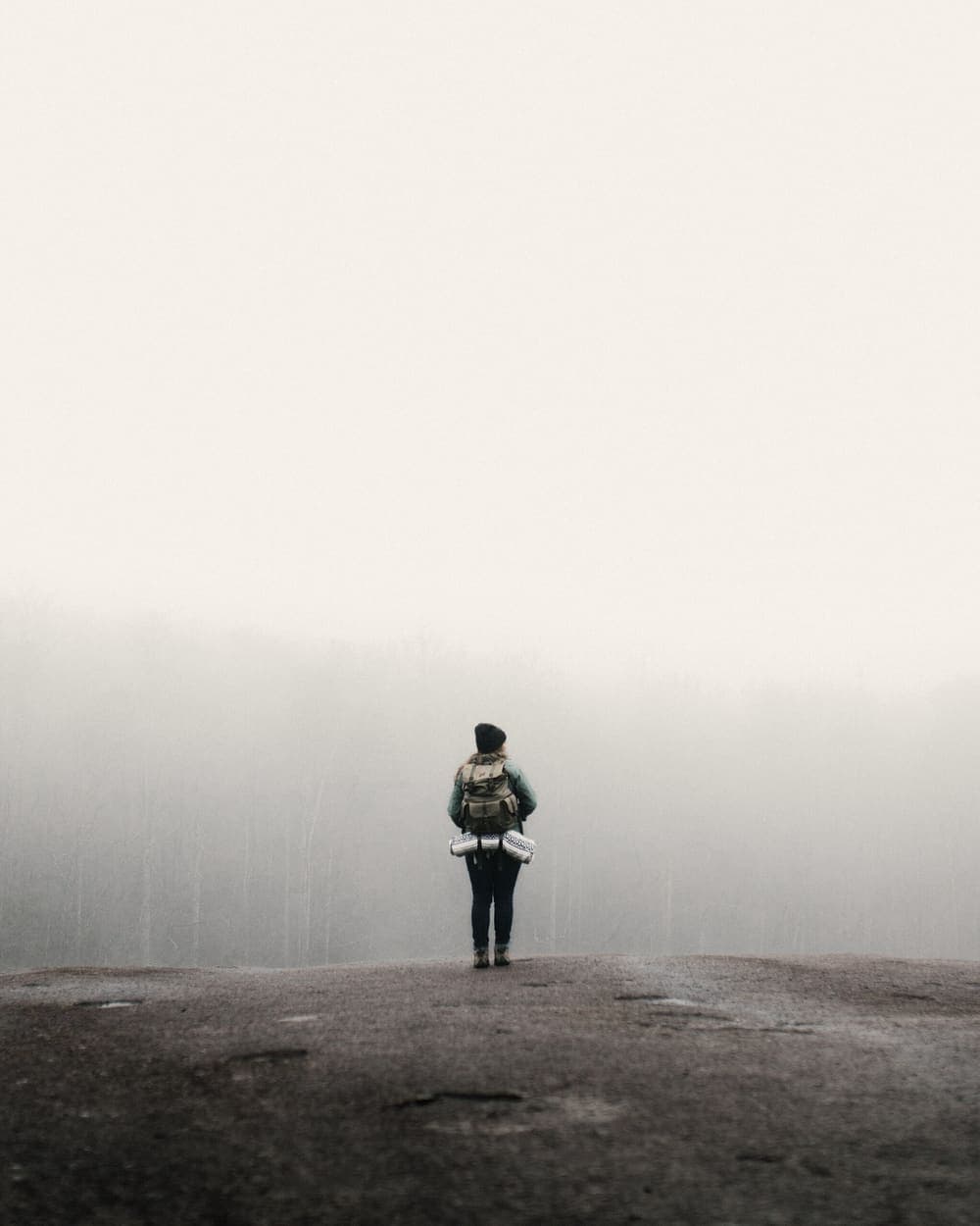 A traveller with a backpack standing in the mist
