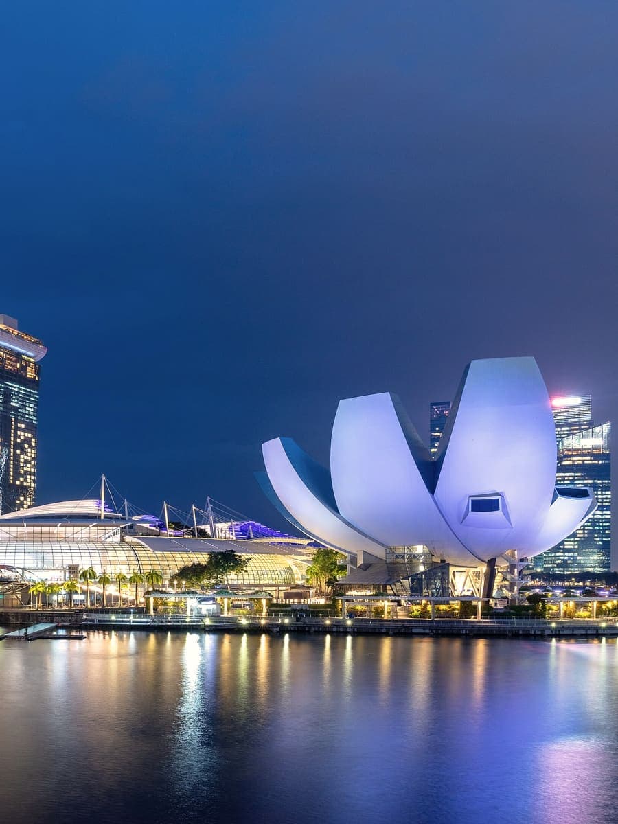 The ArtScience Museum and Marina Bay waterfront lit up at blue hour